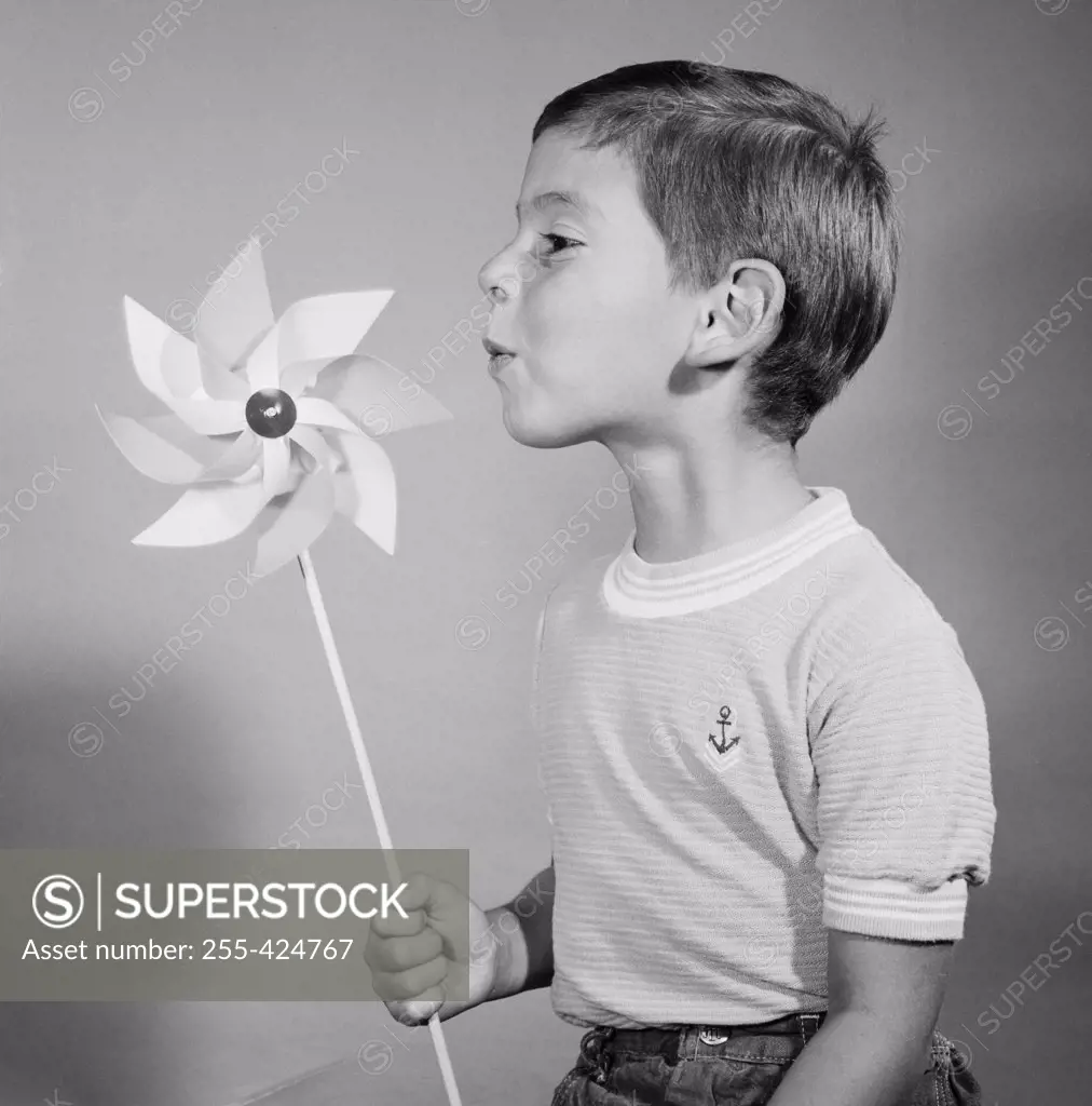 Studio shot of boy blowing at pinwheel