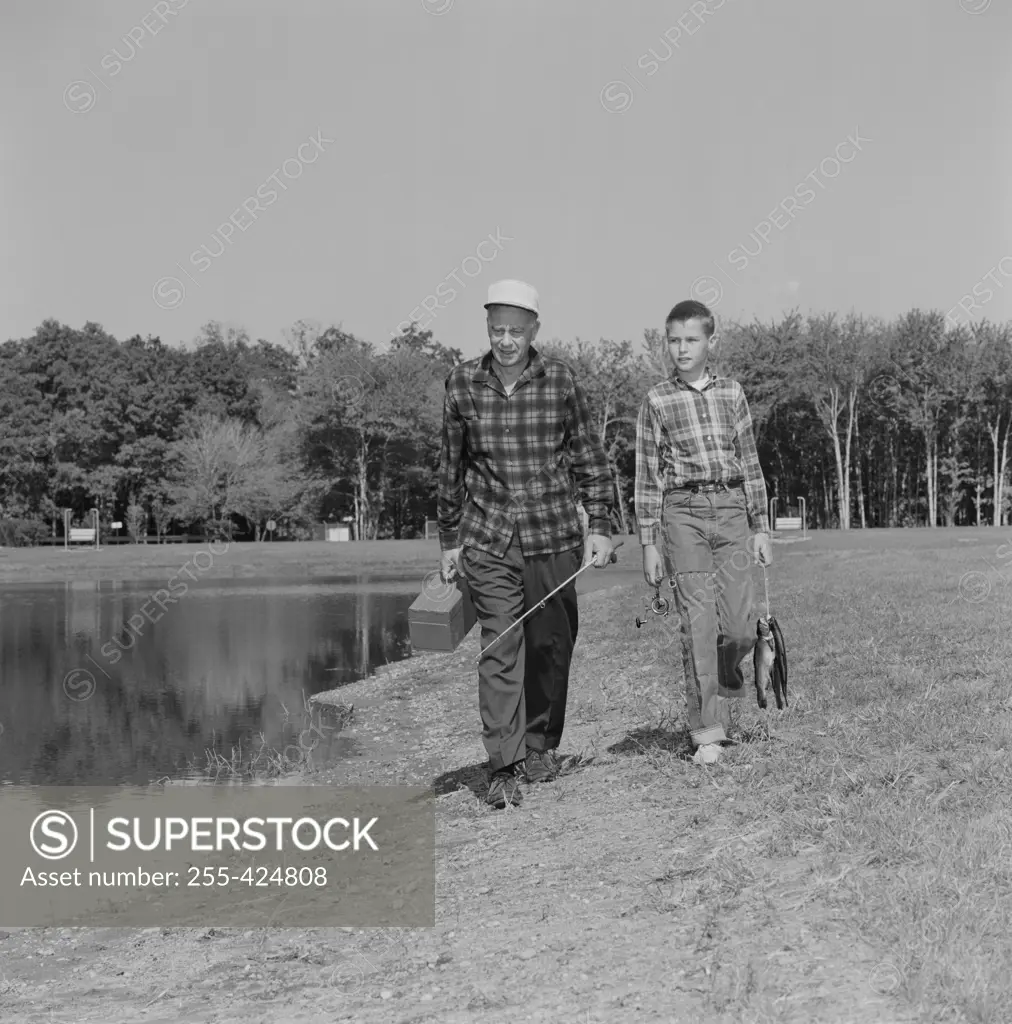 USA, Father and son with fish and fishing equipment