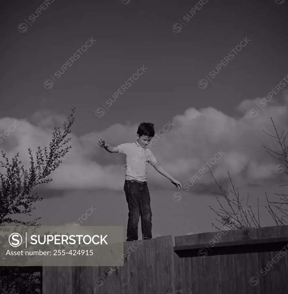 Boy balancing on fence