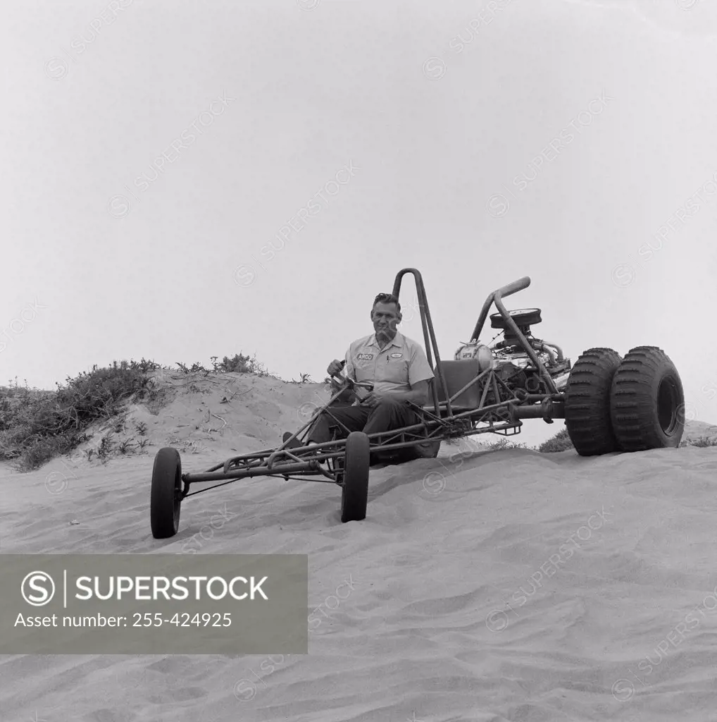 Man riding beach buggy on sand dunes