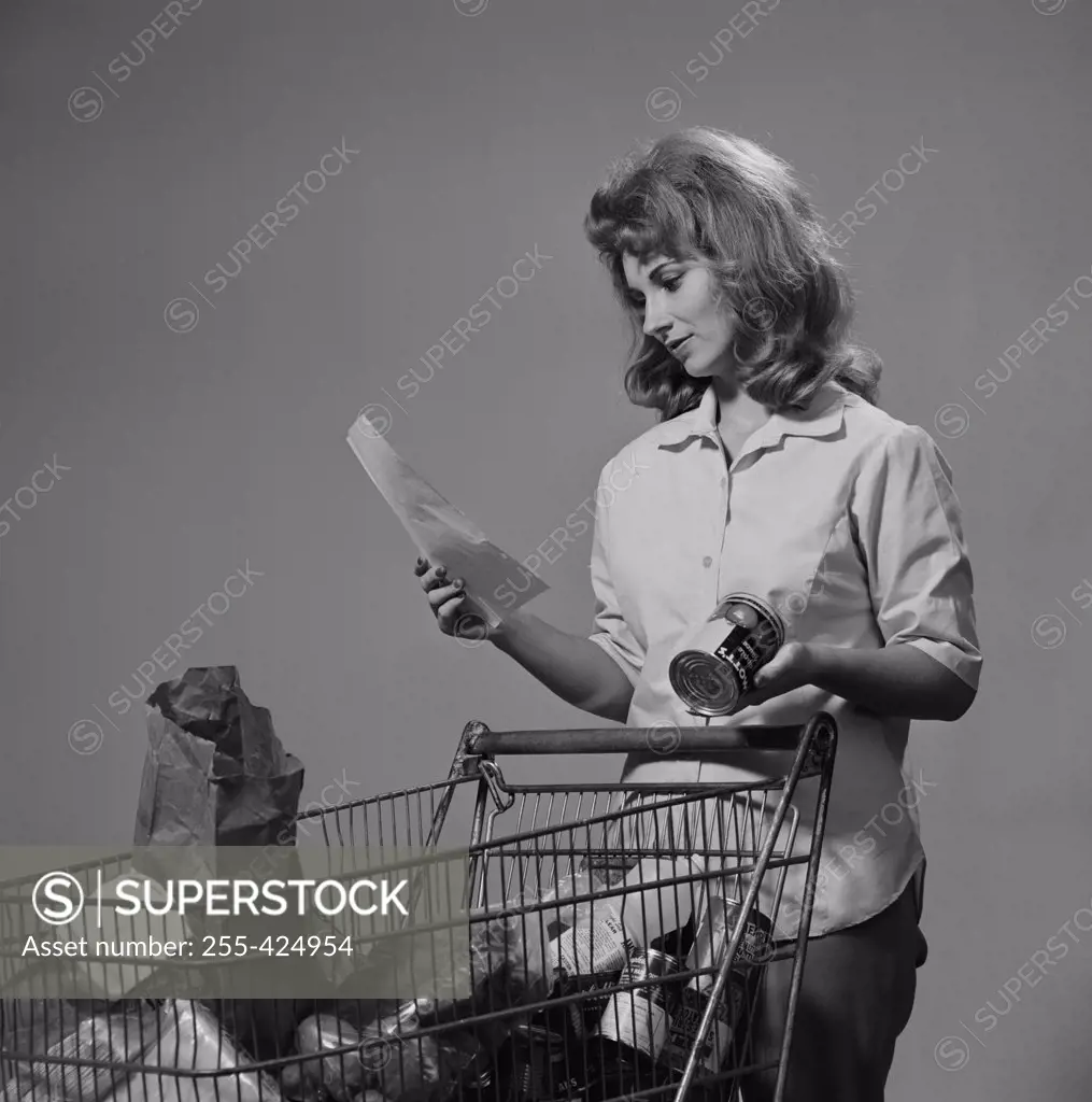 Young woman with groceries in shopping trolley