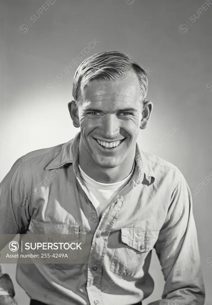 Vintage Photograph. Man wearing denim work shirt smiling at camera