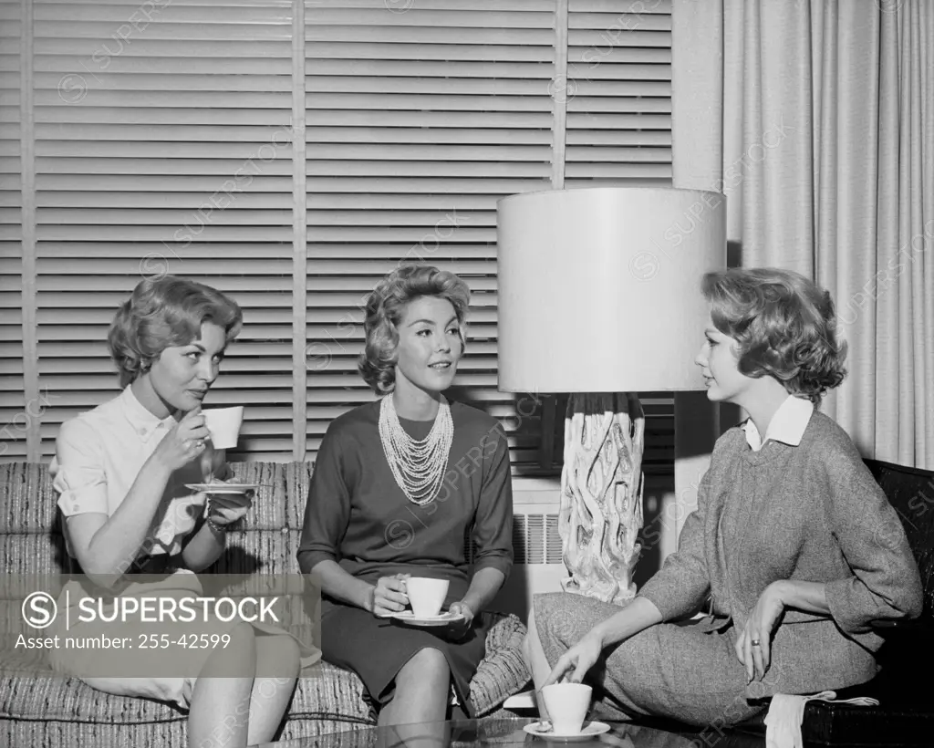 Three young women drinking coffee