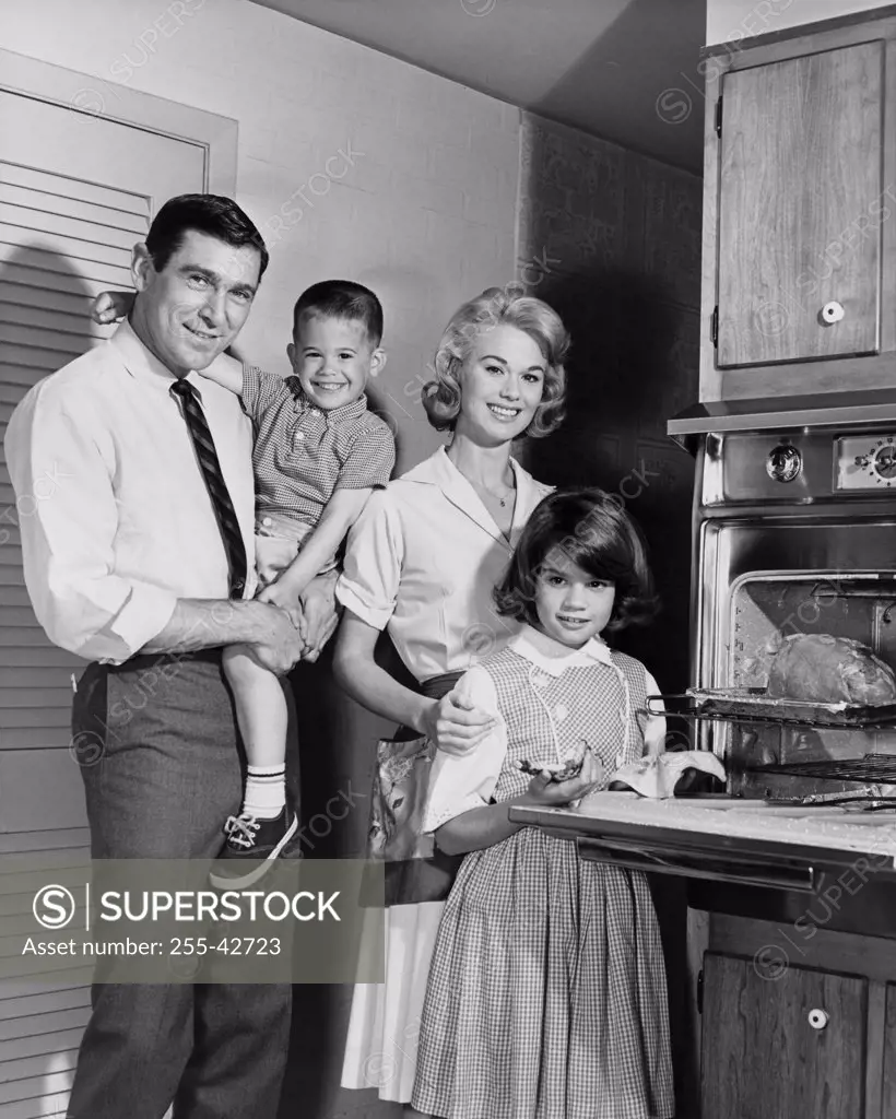 Portrait of parents and their children standing in a kitchen