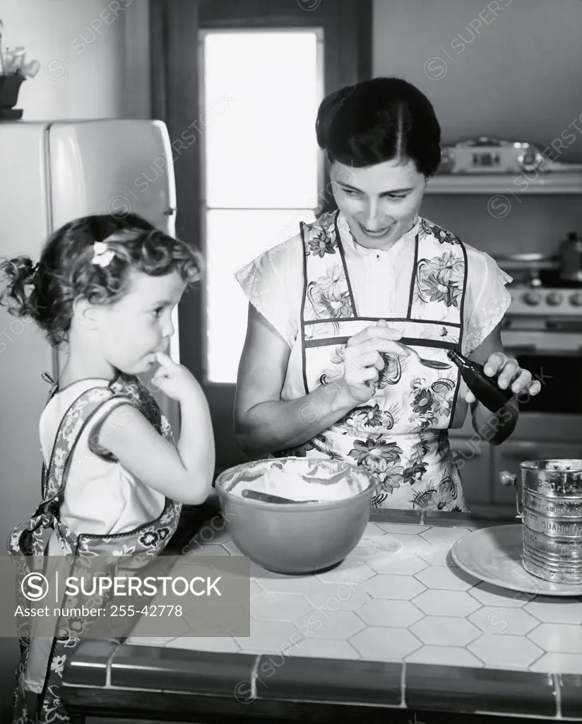 Mid adult woman and her daughter preparing food in a kitchen