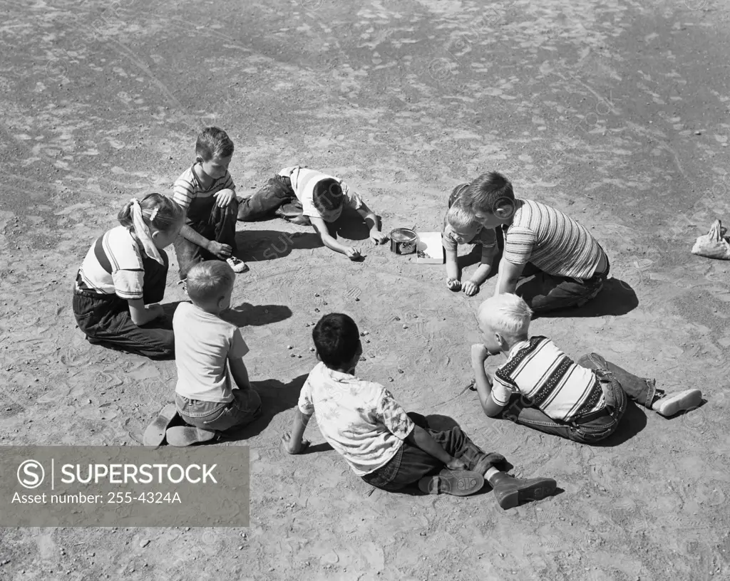 High angle view of a group of children playing with marbles