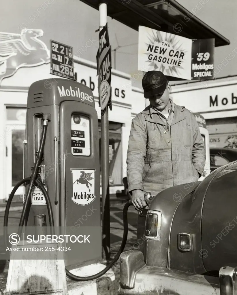Gas station attendant filling up a car