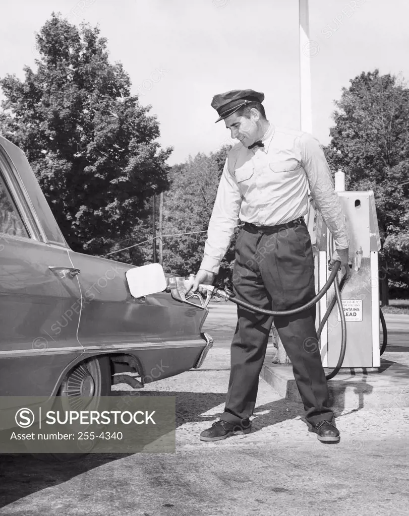Mature man refueling a car at a gas station