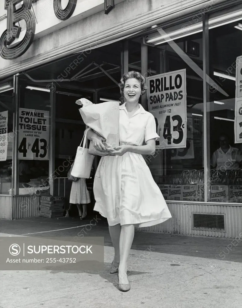 Mid adult woman walking in front of a store