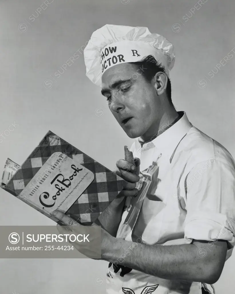 Close-up of a mid adult man reading a cookbook