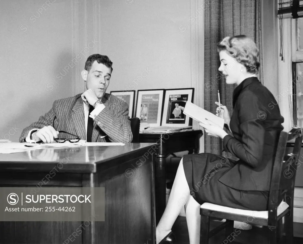 Businessman looking at the legs of his secretary sitting beside him
