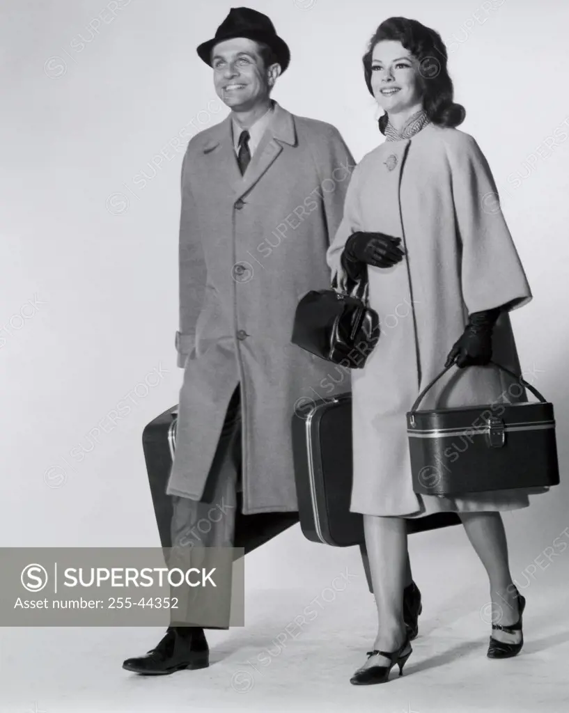 Mid adult couple walking with luggage