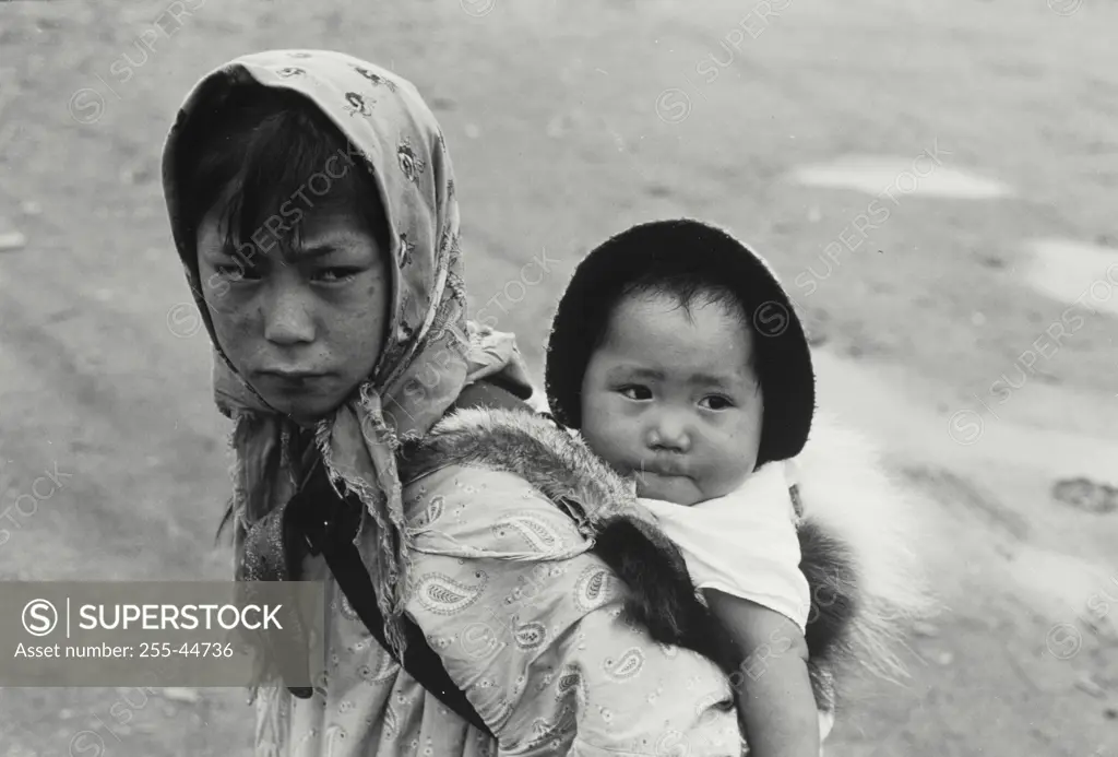 Vintage Photograph. Eskimo Girl with little sister on back.