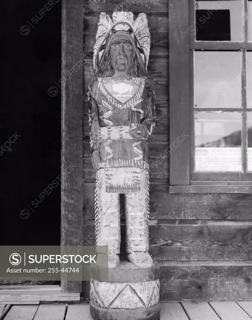 Sculpture of Native American tribal man near a window