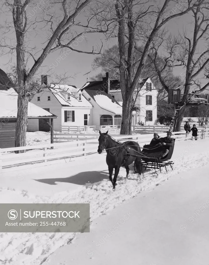 Two people riding in a horsedrawn sleigh, USA