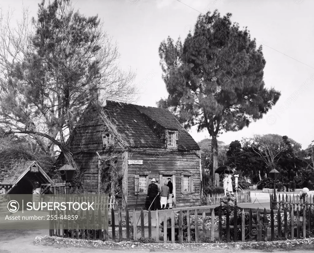 Four people standing in front of a schoolhouse, Oldest Wooden Schoolhouse, St. Augustine, Florida, USA