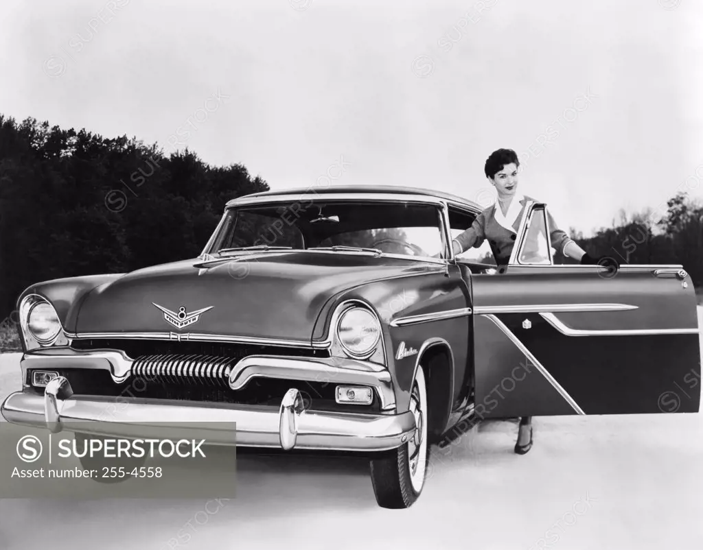 Woman opening a car door of a 1955 Plymouth Belvedere sport coupe