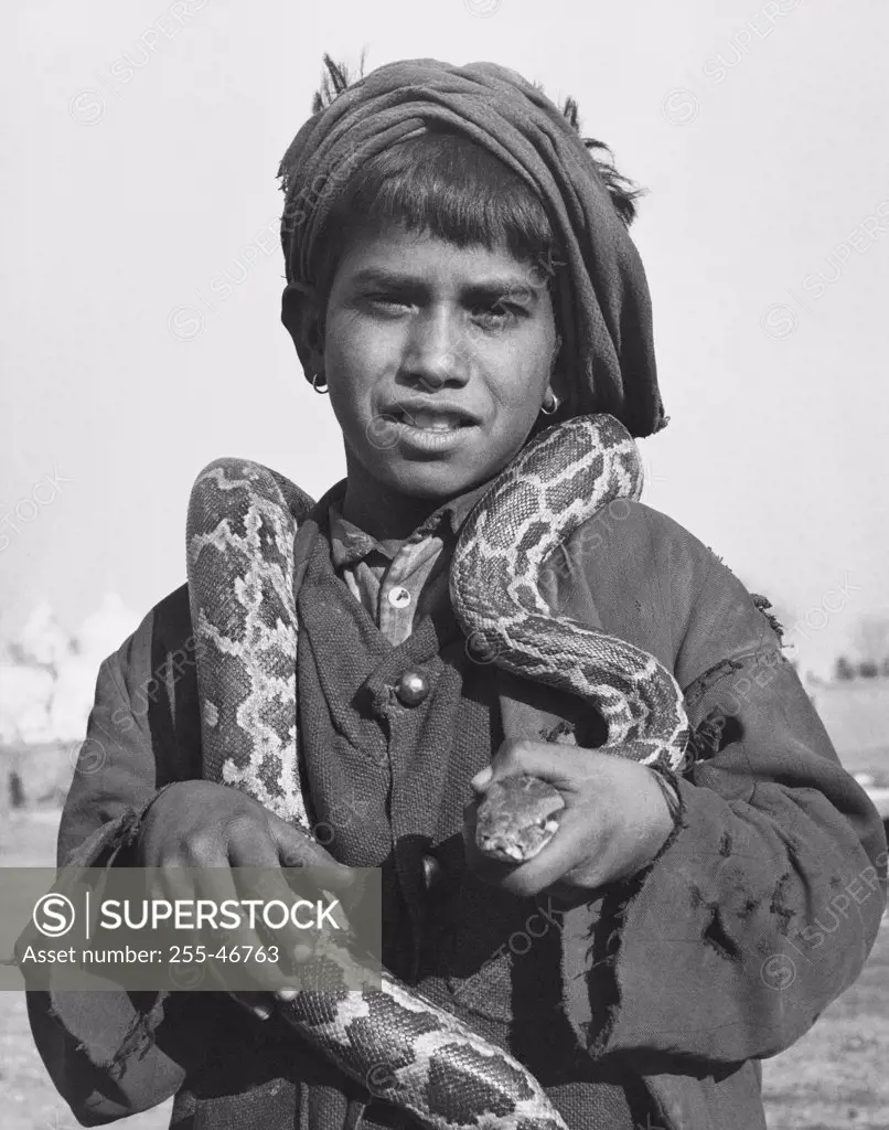 Boy holding a snake around his neck