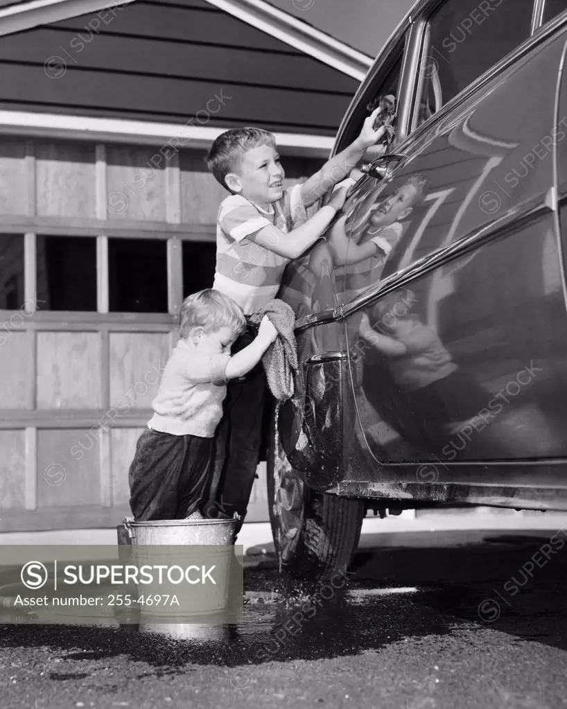 Two boys cleaning a car
