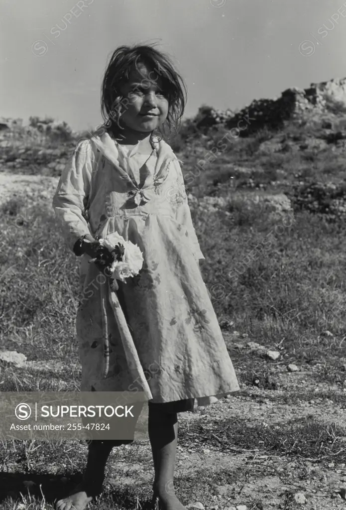 Vintage Photograph. Young Syrian girl standing in field.