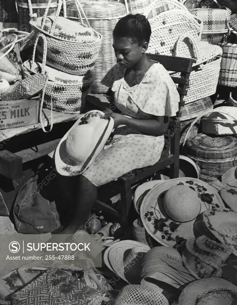 Vintage Photograph. Local girl making articles for tourist trade while waiting for buyers, Kingston, Jamaica