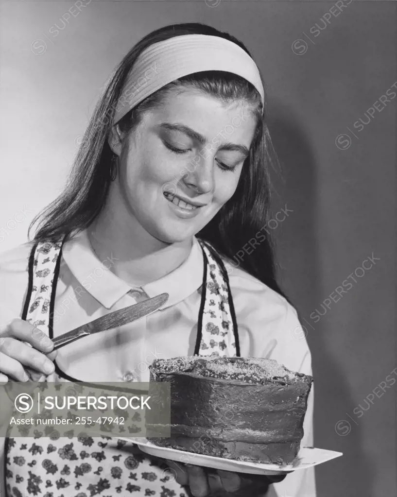 Teenage girl holding a cake and smiling