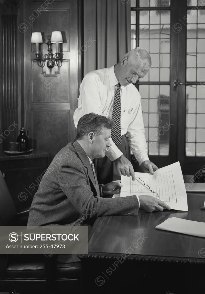 Vintage Photograph. Two business men in office discussing document. Frame 7