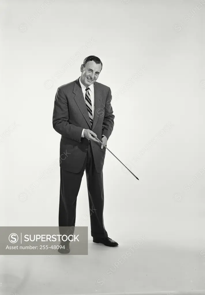 Vintage Photograph. Man in suit and tie standing on white background holding pointing stick. Frame 2