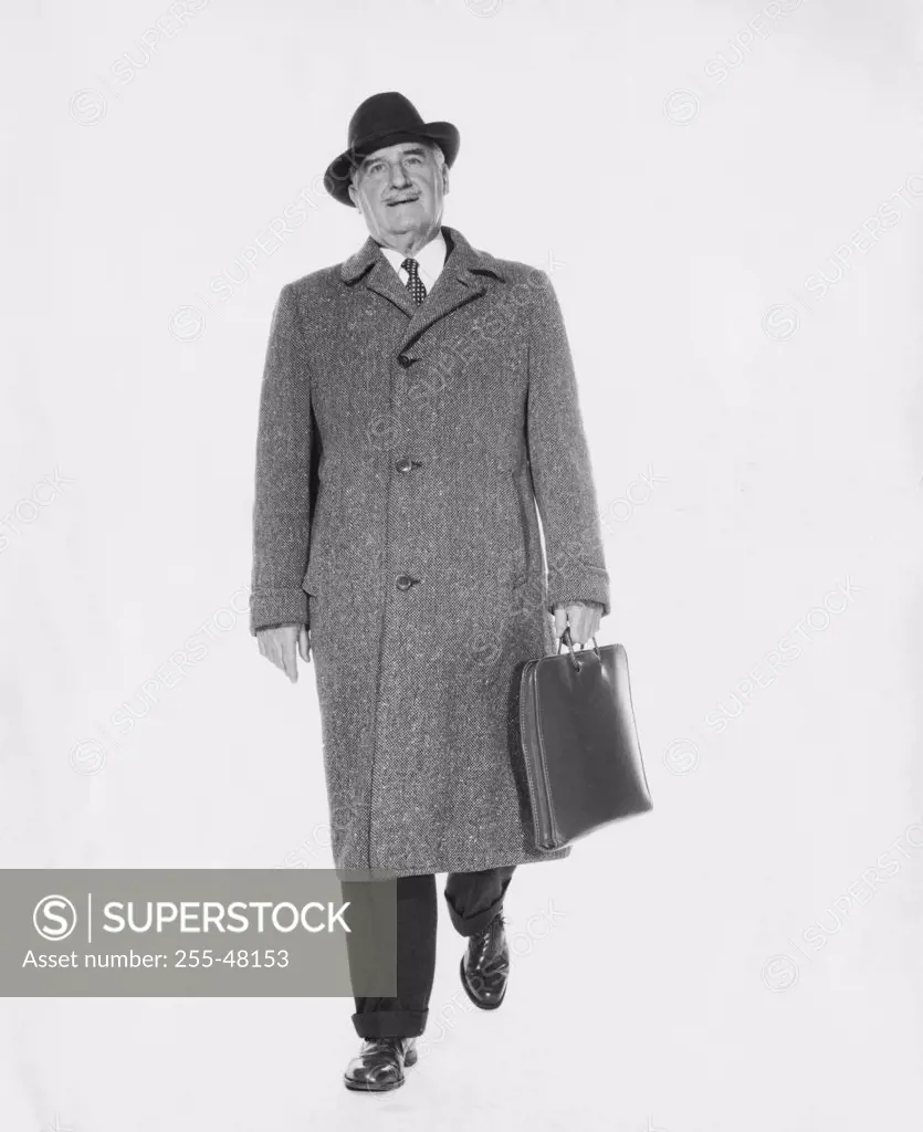 Studio portrait of businessman carrying briefcase