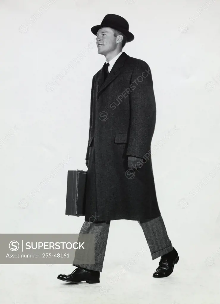 Side profile of a businessman carrying a briefcase