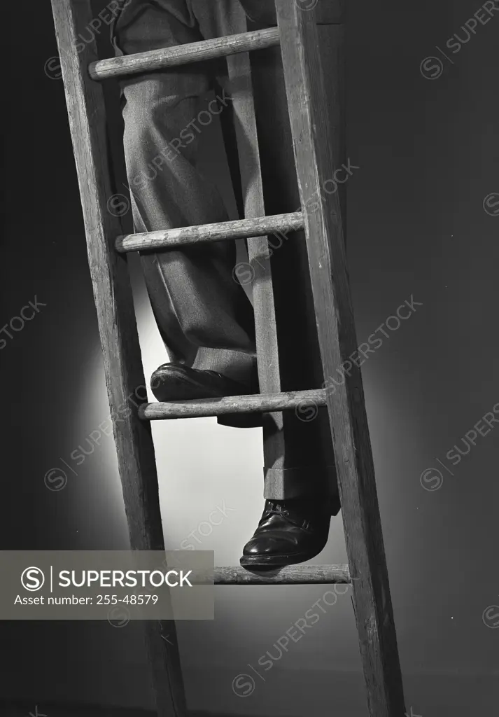 Vintage photograph. Low section view of a person climbing a ladder