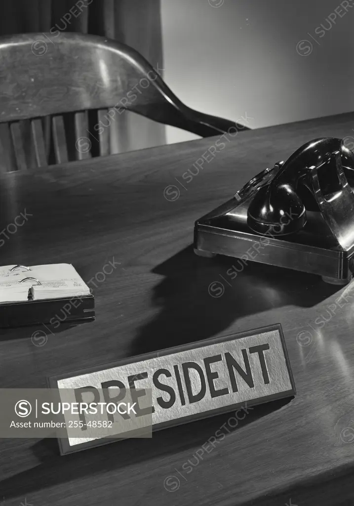 Vintage Photograph. Desk with telephone and president title card.