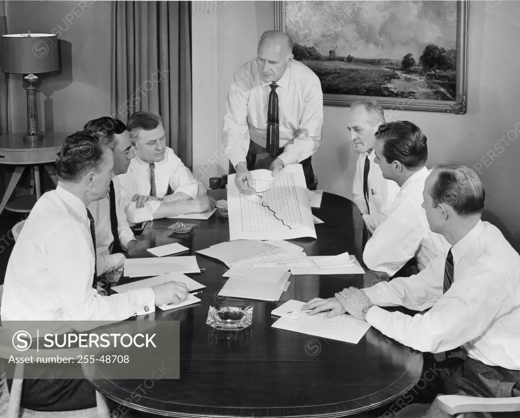 Business executives discussing chart in conference room