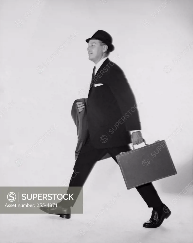 Side profile of businessman carrying briefcase and an overcoat