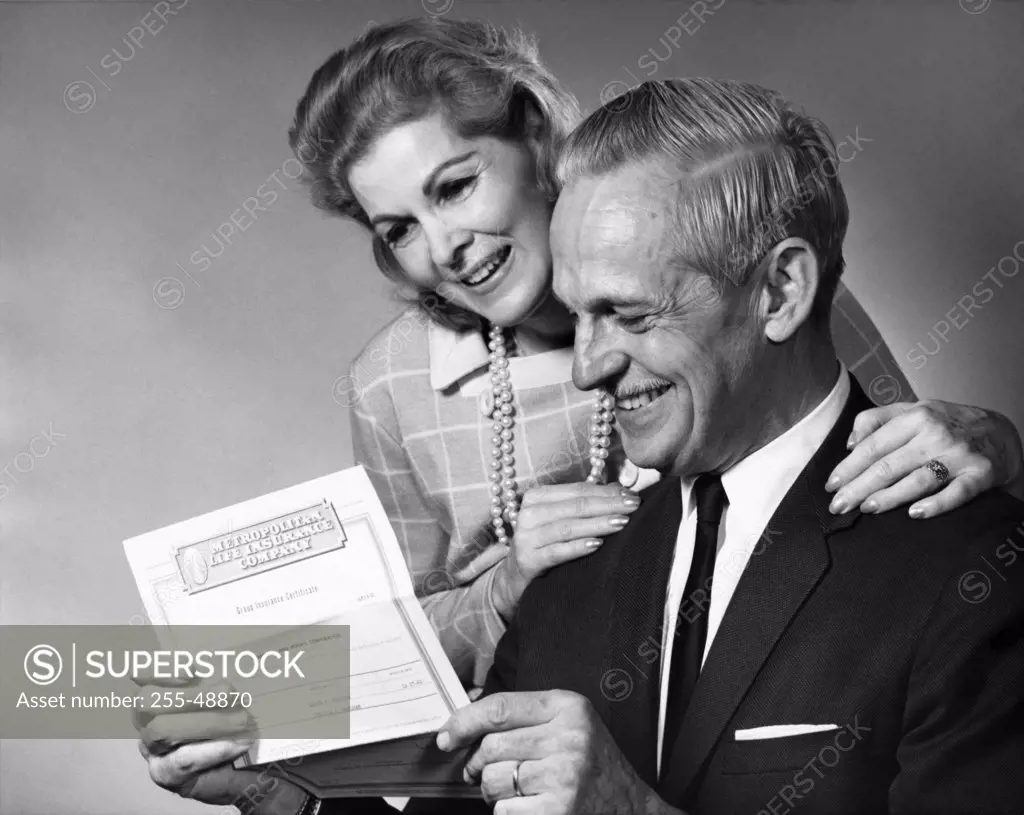 Senior couple reading a document and smiling