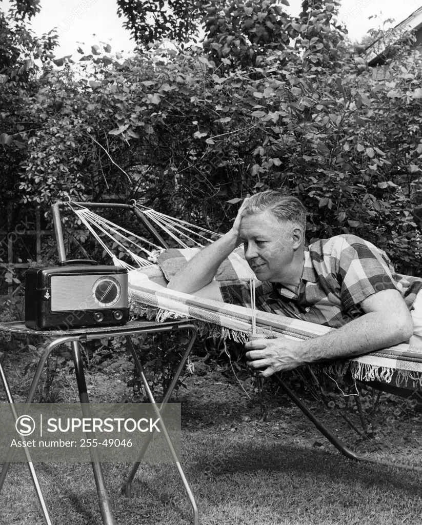 Man relaxing in hammock listening to radio