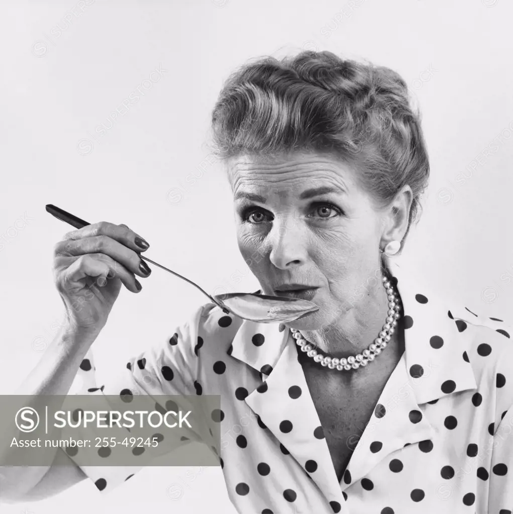 Senior woman tasting food with a spoon