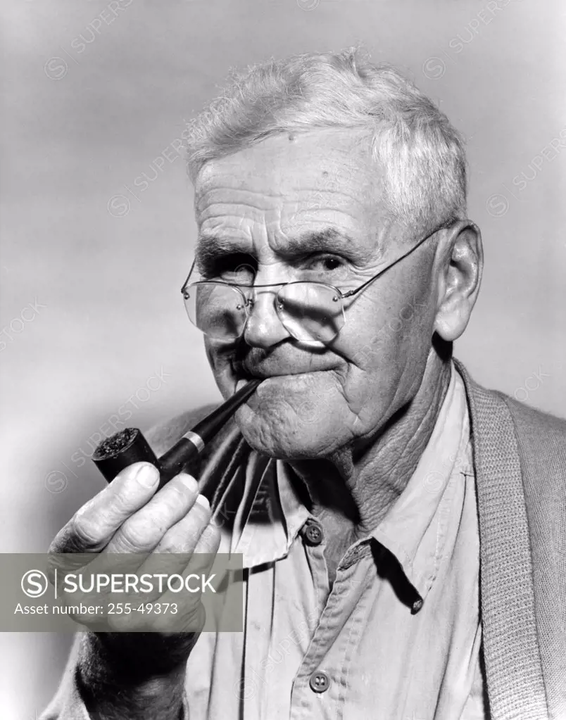 Portrait of senior man with pipe, studio shot