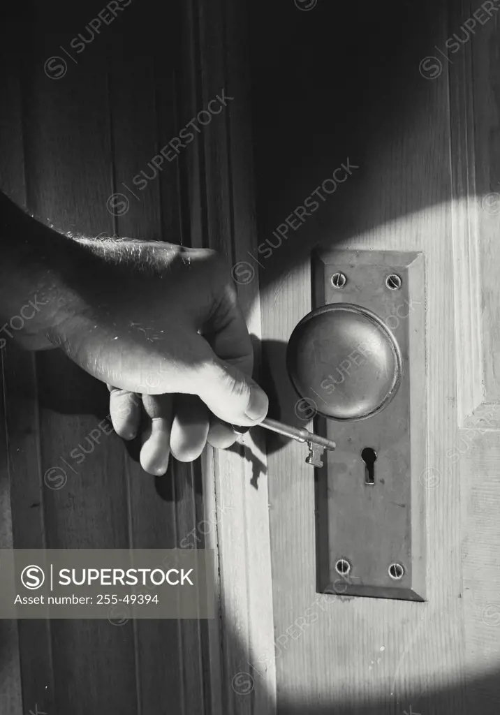 Vintage photograph. Close-up of person opening lock with key