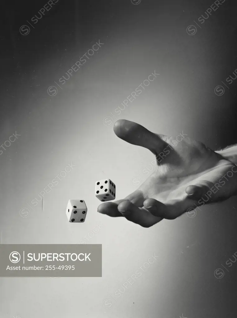 Vintage photograph. Close-up of a person's hand tossing two dice