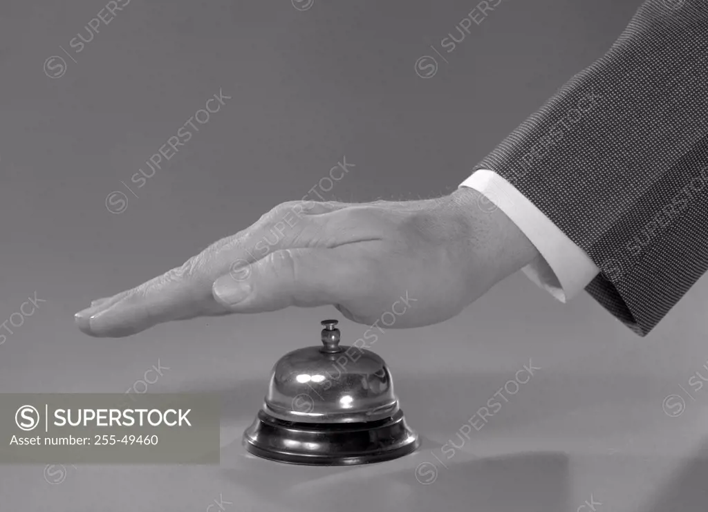 Studio shot of male hand ringing service bell