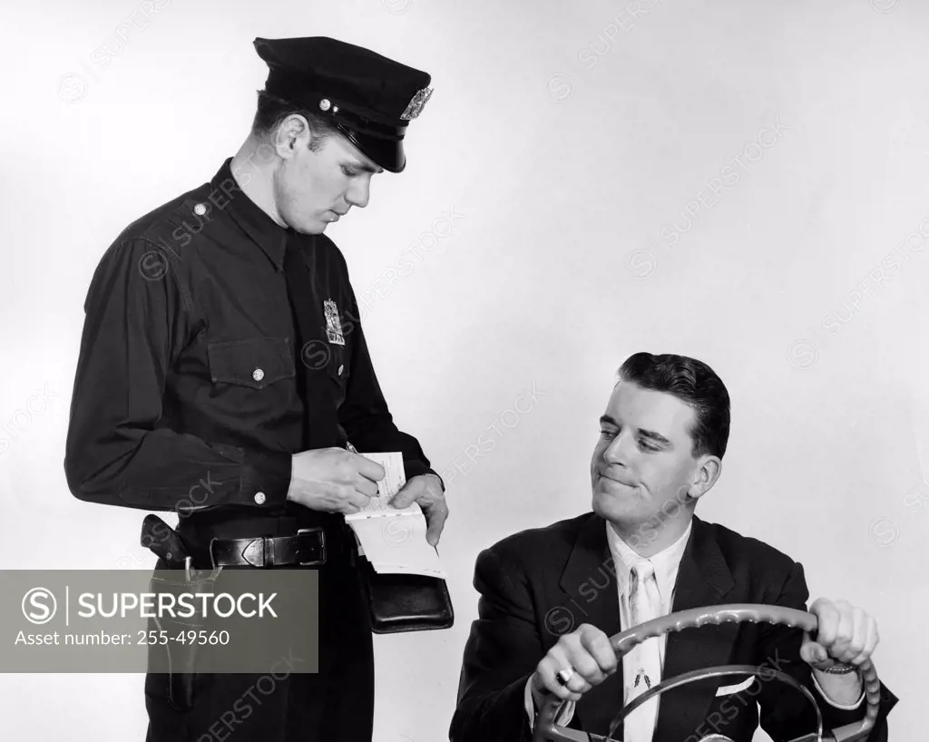 Studio shot of policeman giving ticket to driver