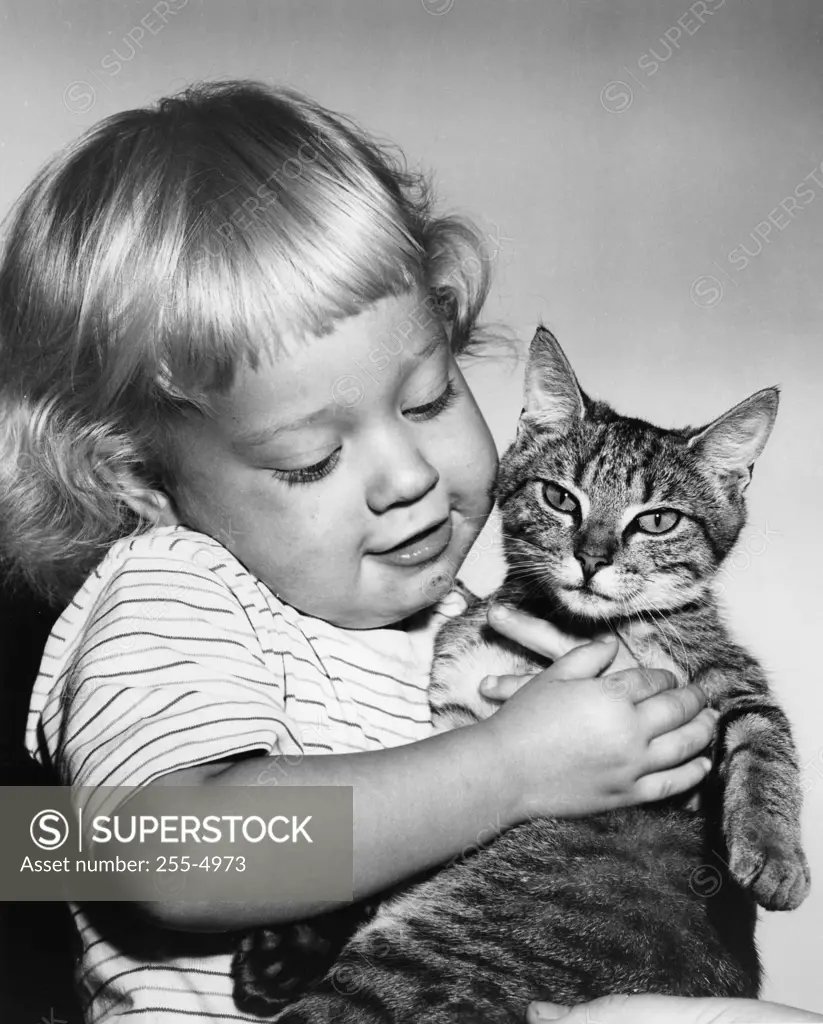 Child holding cat, studio shot