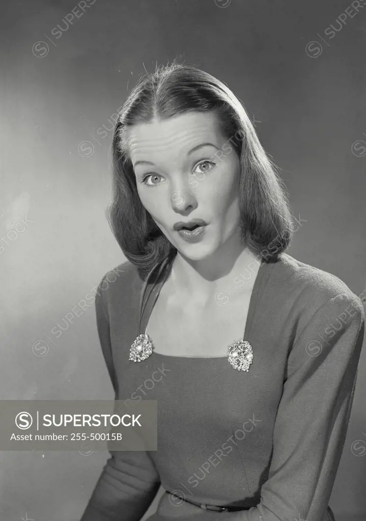Woman in low cut blouse raising eyebrows at camera