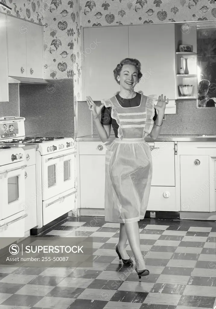 Vintage Photograph. Woman wearing apron standing in kitchen. Frame 1