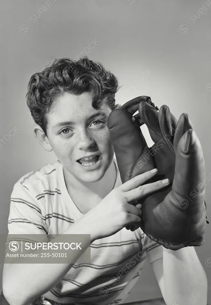 Vintage photograph. Boy holding up hand sign to baseball glove