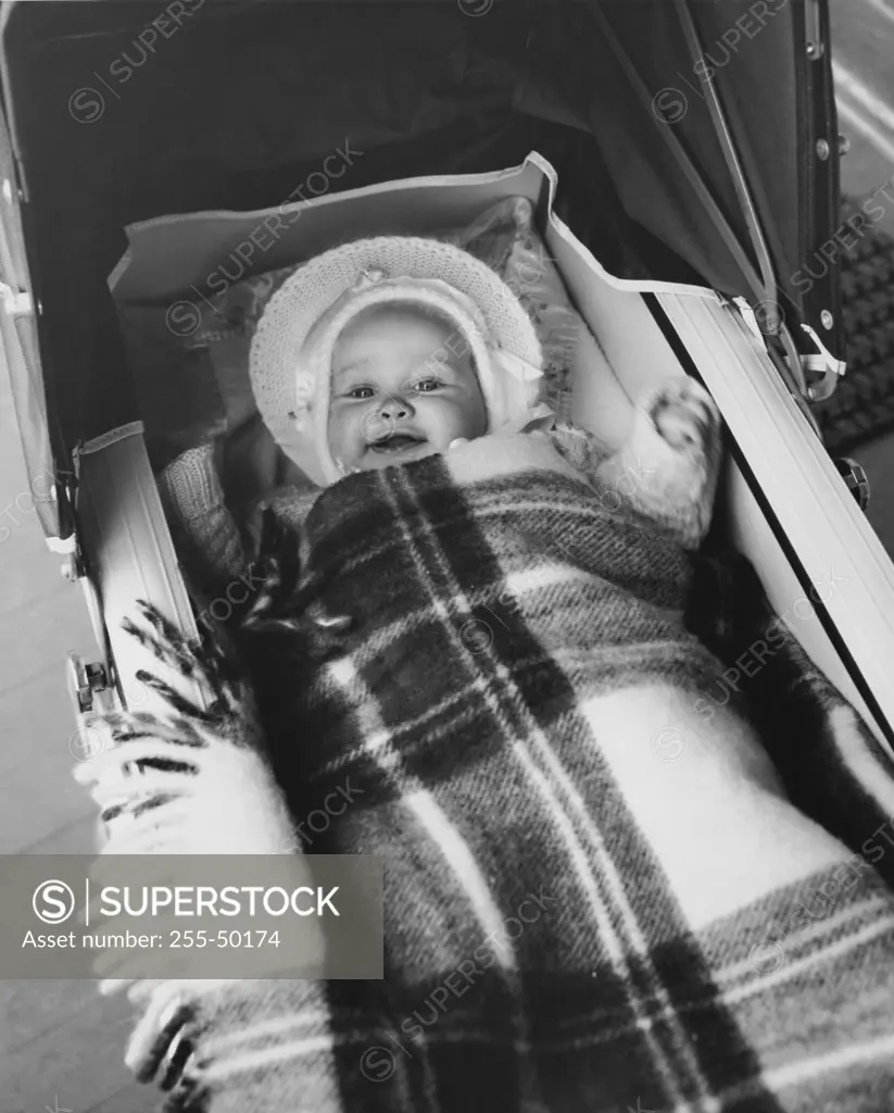 High angle view of a baby girl lying in a baby carriage