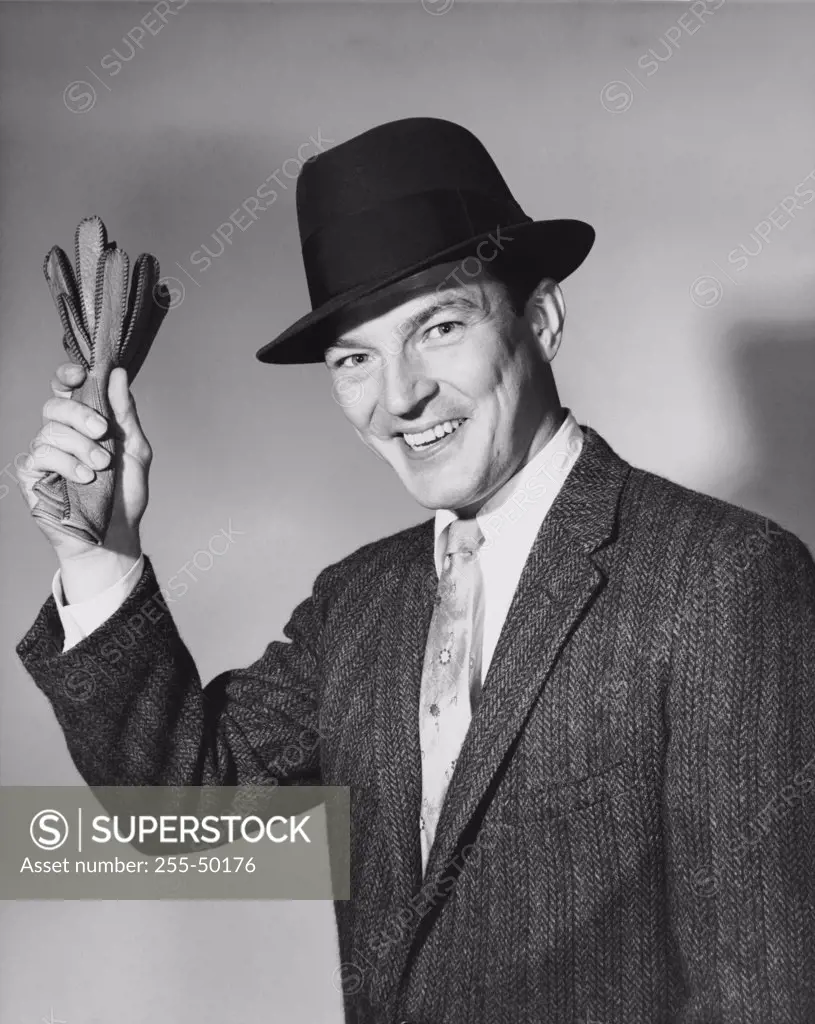 Mid adult man holding a pair of gloves