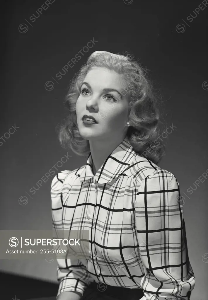 Vintage photograph. Blonde woman in plaid blouse looking up