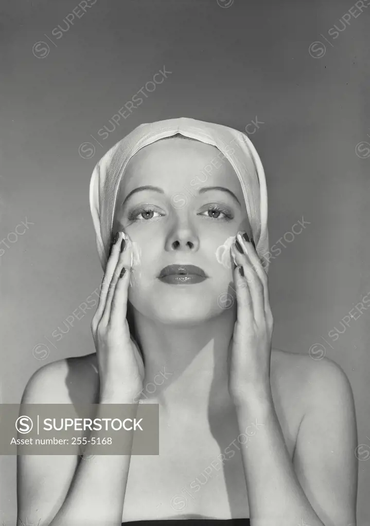 Vintage Photograph. Woman with towel over head washing face as if looking in mirror